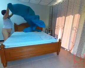 Nudist housekeeper Regina Noir makes the bedding in the bedroom. Naked maid. Naked housewife. c2